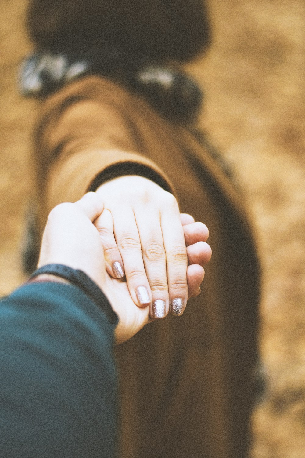 person in black long sleeve shirt holding hands with woman in white long sleeve shirt