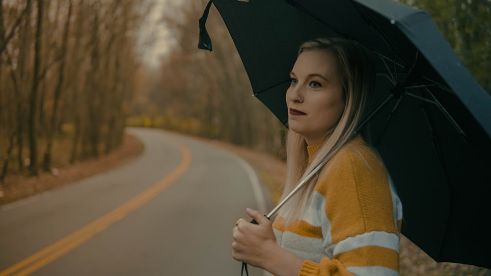 woman in white and brown coat holding umbrella