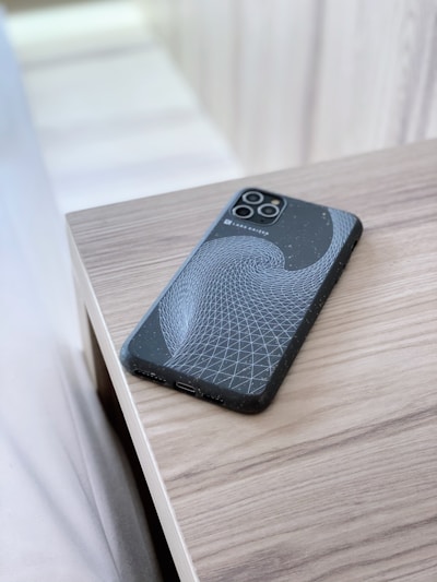 Close-up of a sleek, precision-cut wooden phone case with intricate geometric patterns glowing under soft light.