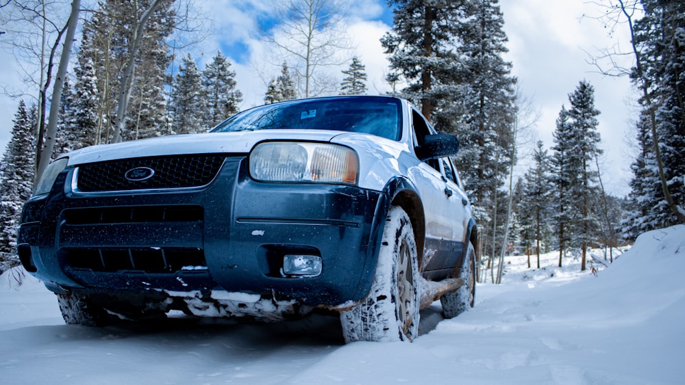 blue car on snow covered ground during daytime