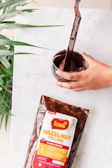 Close-up of Nutella chocolate spread jar with a spoonful of creamy chocolate.