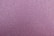 A textured surface composed of fine, closely-packed granules. The overall tone is a mix of pink and purple hues with subtle variations across the surface.