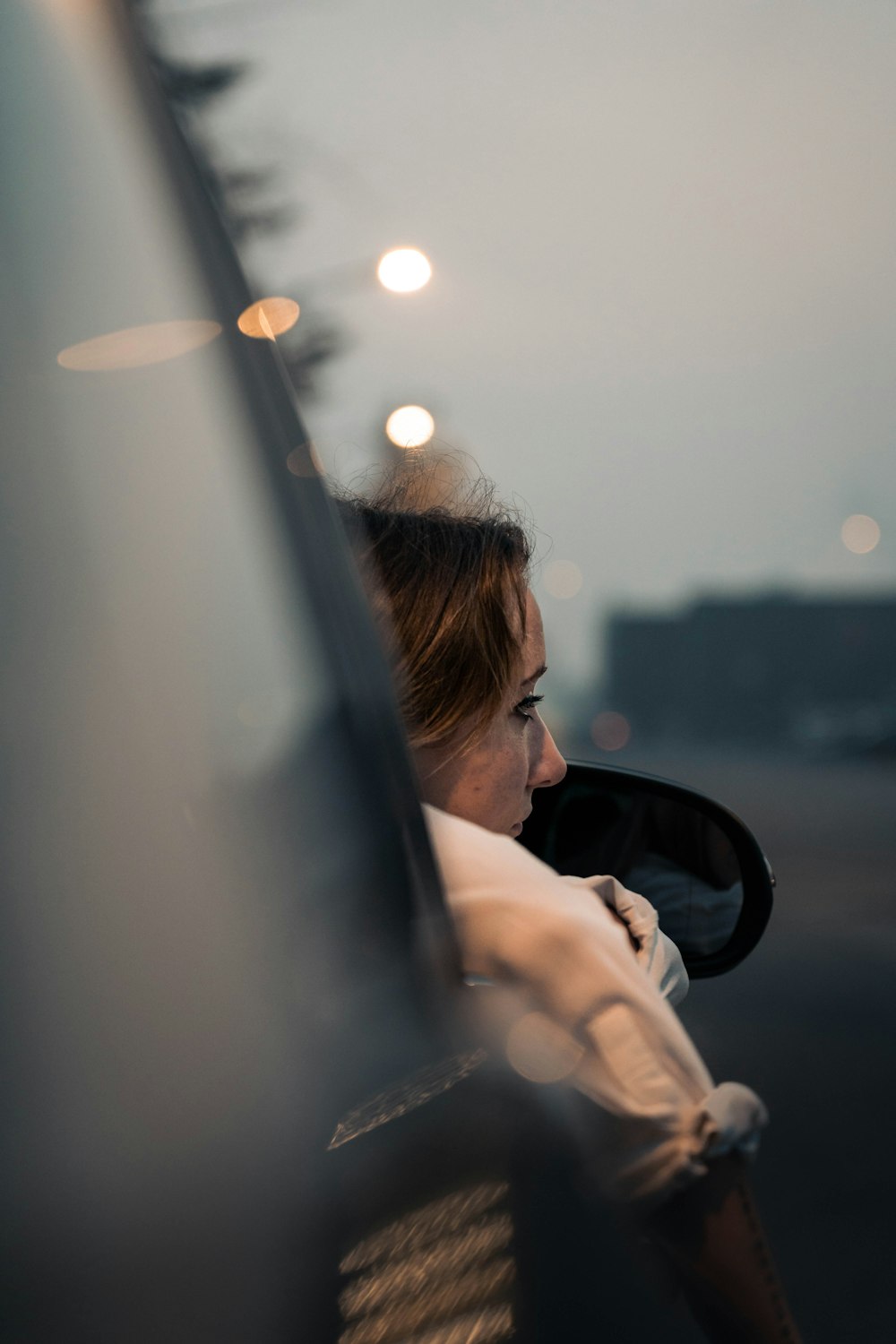 woman in white shirt driving car during daytime