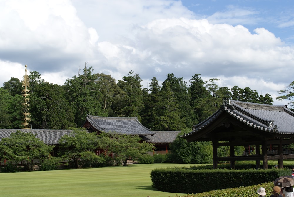 black and white house surrounded by green grass field and trees under white clouds and blue