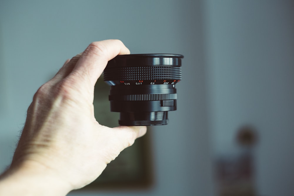 person holding black camera lens