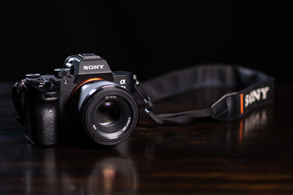 black and silver nikon dslr camera on brown wooden table