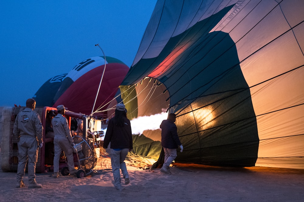 people standing near blue and brown hot air balloon during daytime