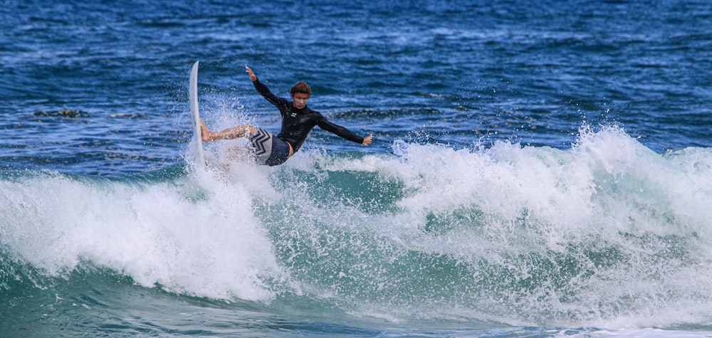 man surfing on sea waves during daytime