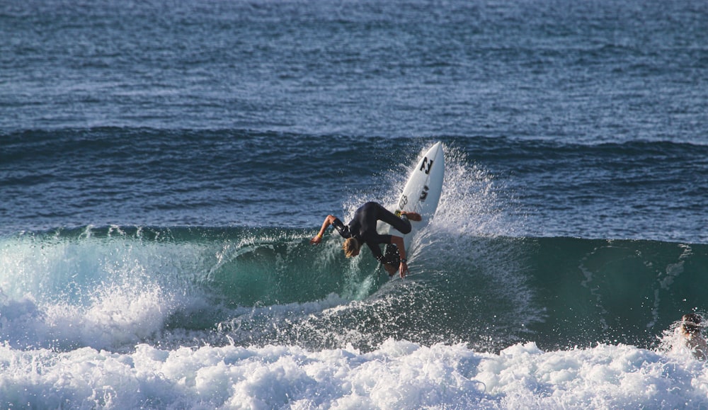 man surfing on sea waves during daytime