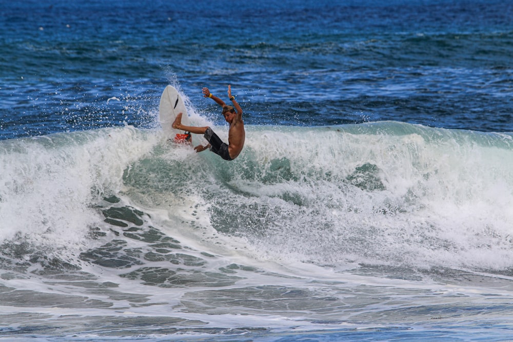 man surfing on sea waves during daytime