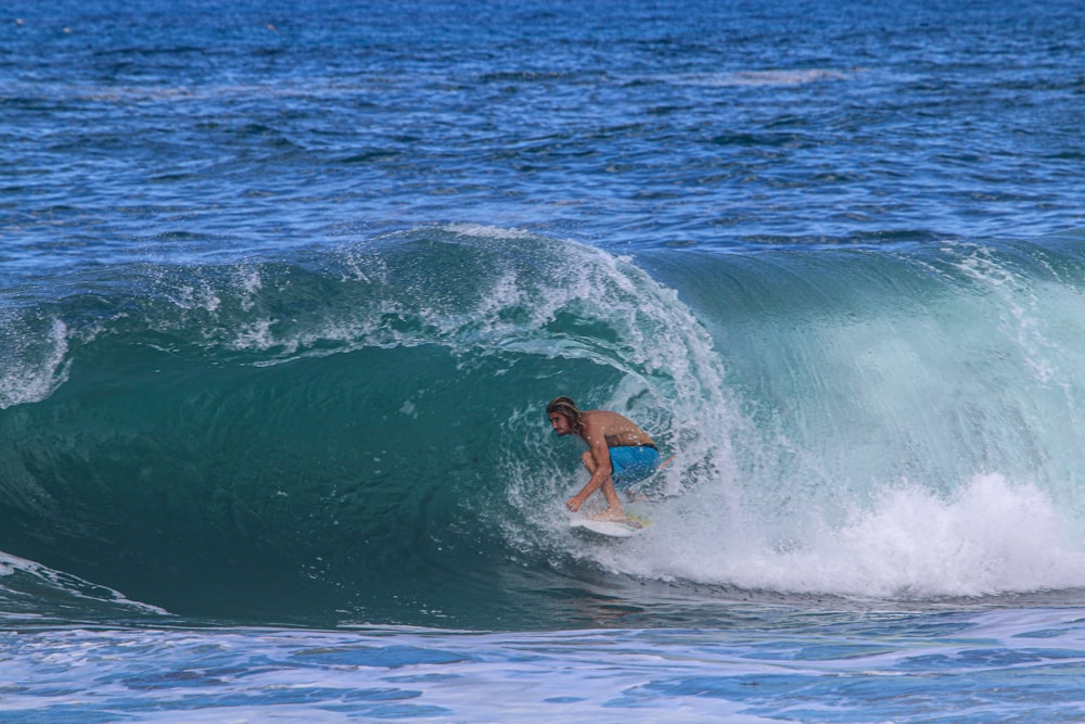 man surfing on sea waves during daytime