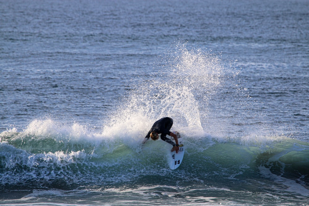 man surfing on sea waves during daytime