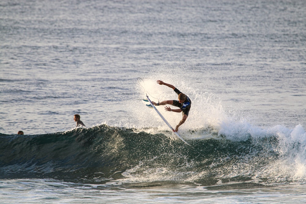 man surfing on sea waves during daytime