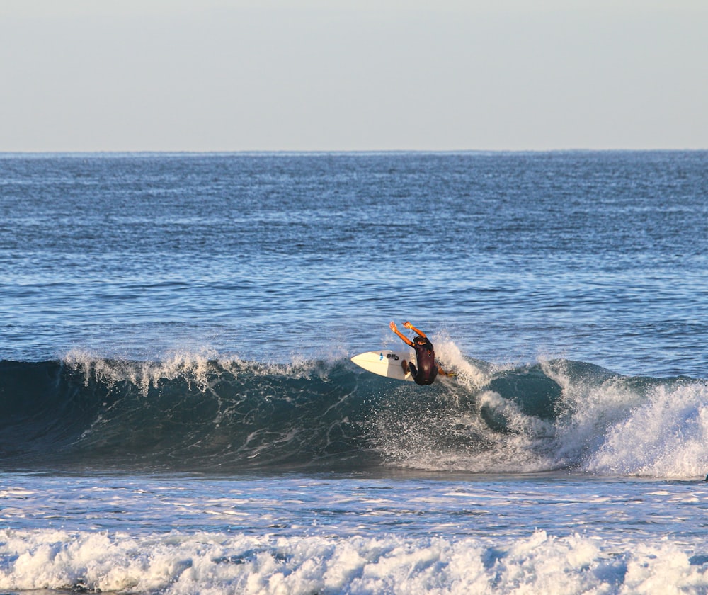 man surfing on sea waves during daytime