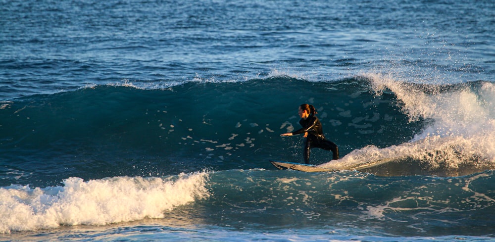 man surfing on sea waves during daytime