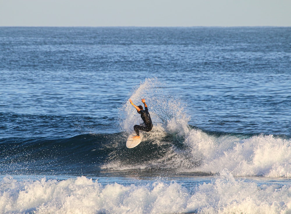 man surfing on sea waves during daytime