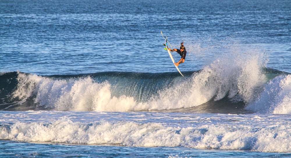 man surfing on sea waves during daytime