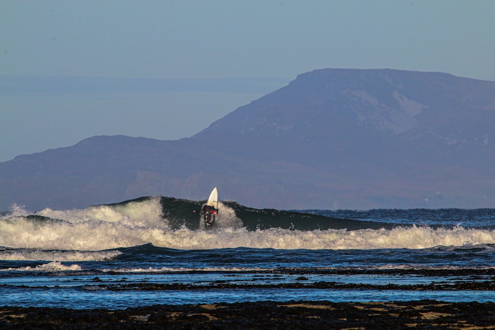 person surfing on sea waves during daytime