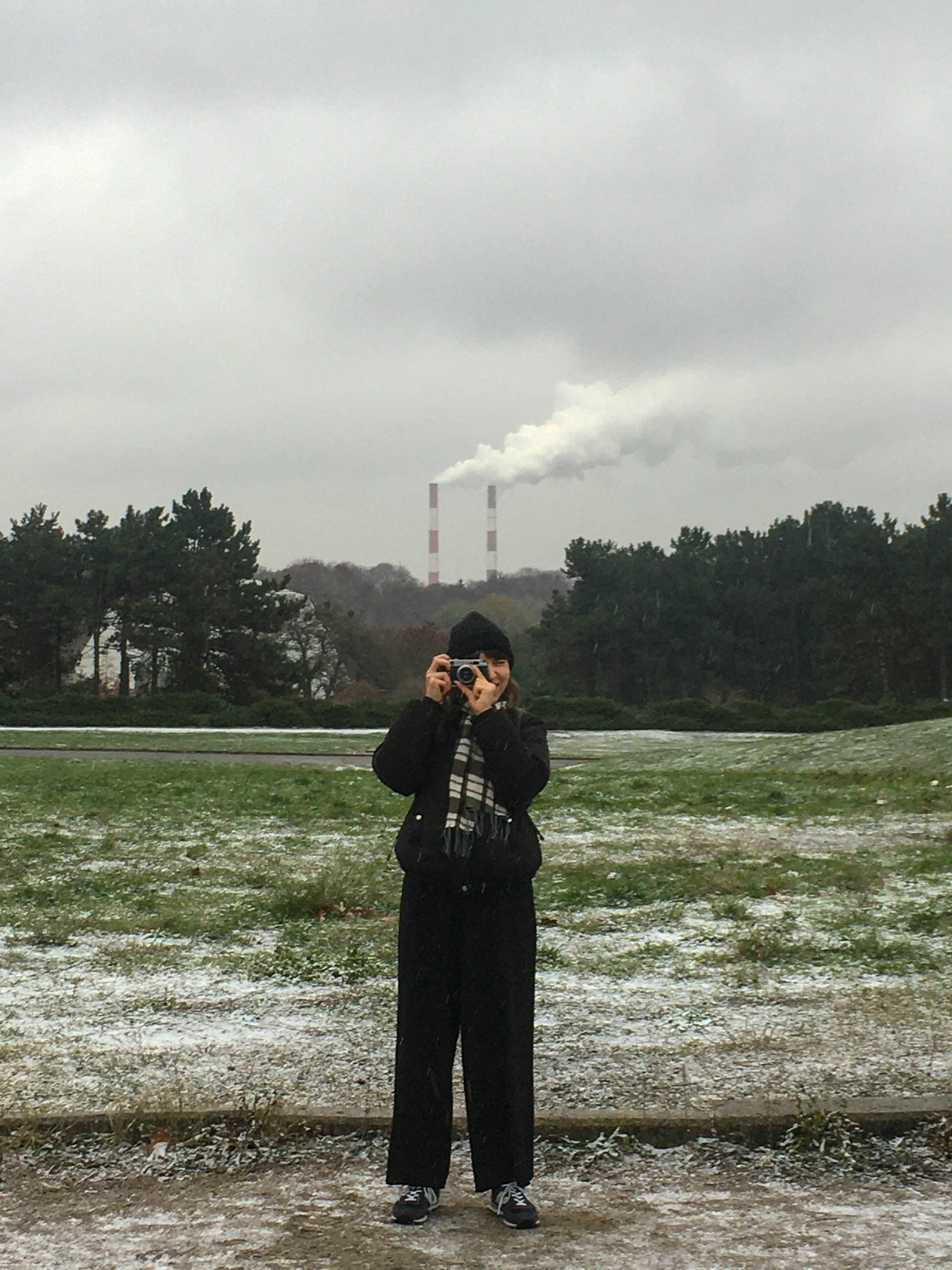 woman in black coat standing on green grass field during daytime