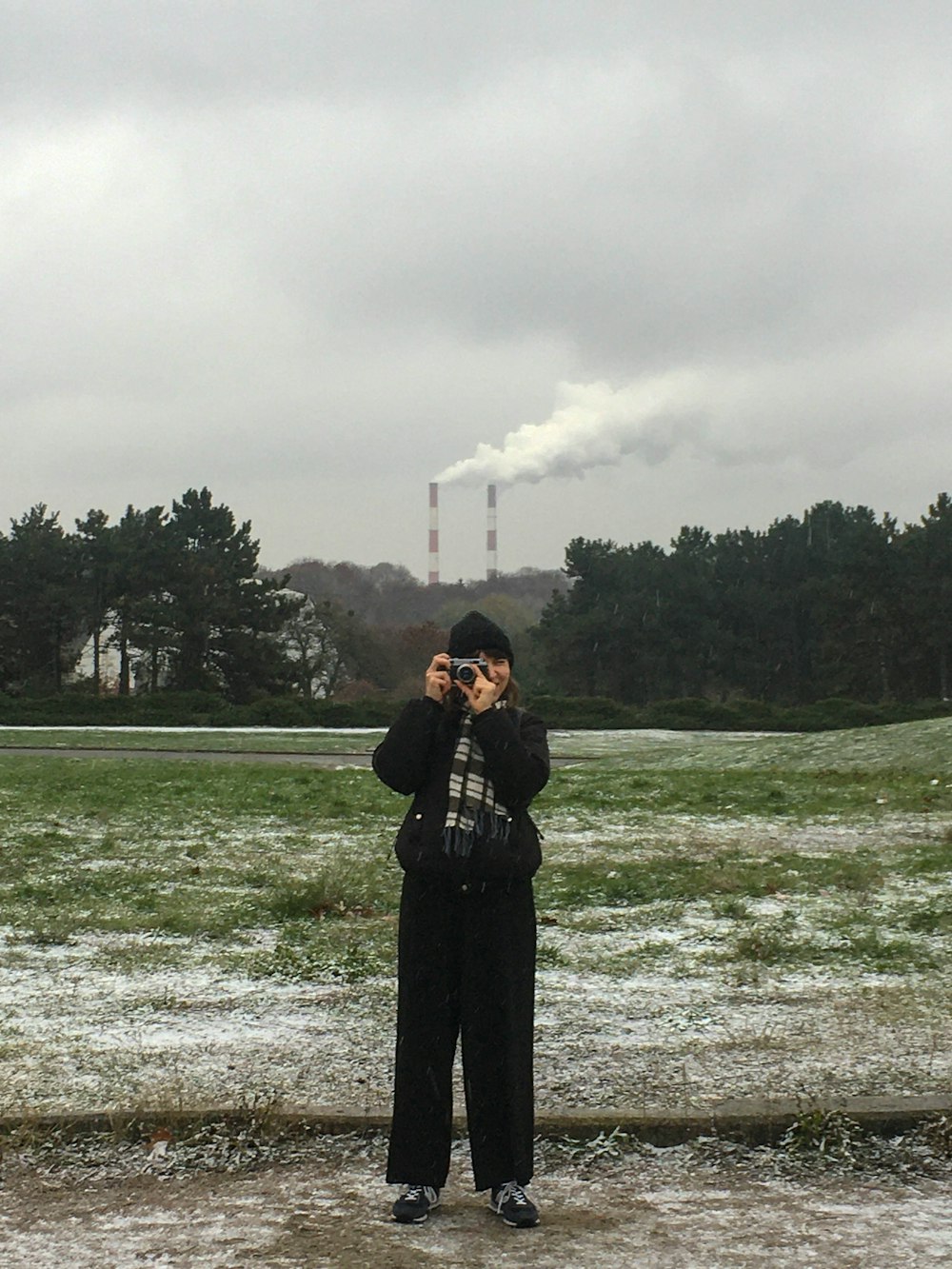 woman in black coat standing on green grass field during daytime