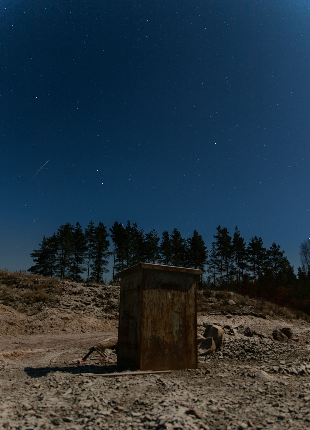 brown wooden post near green trees during night time