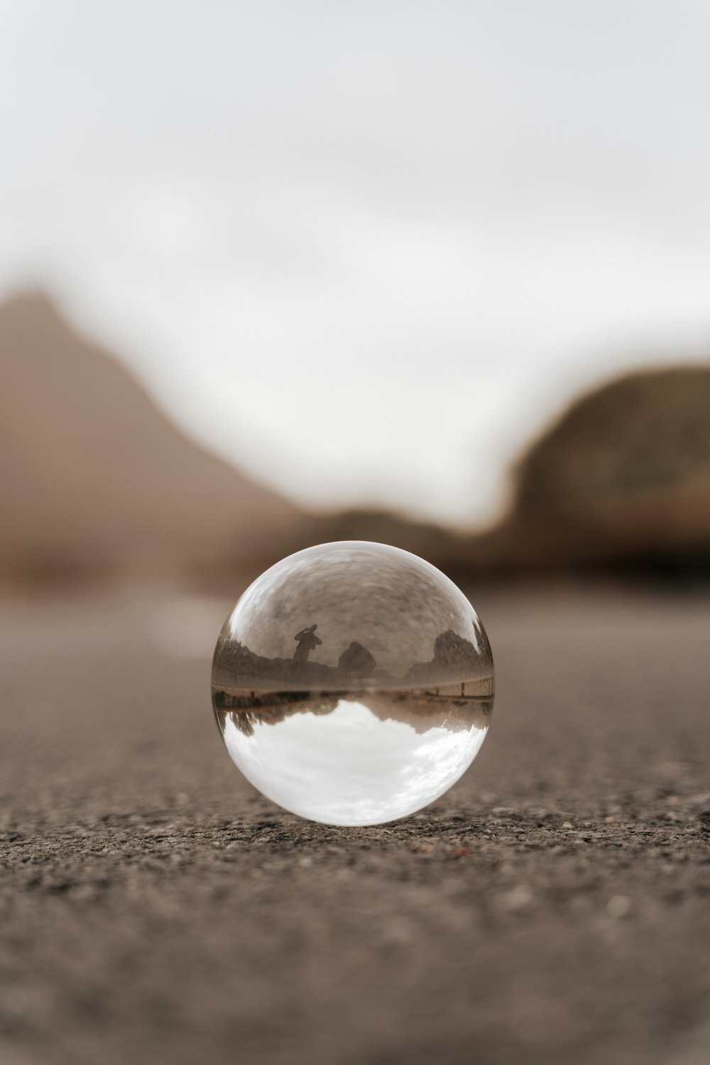 clear glass ball on brown sand