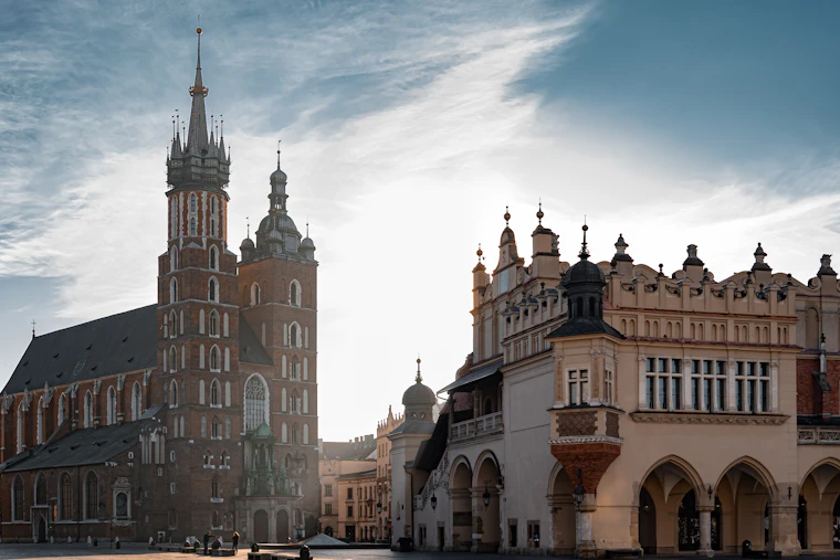 Historic brick buildings in Kraków under a clear blue sky