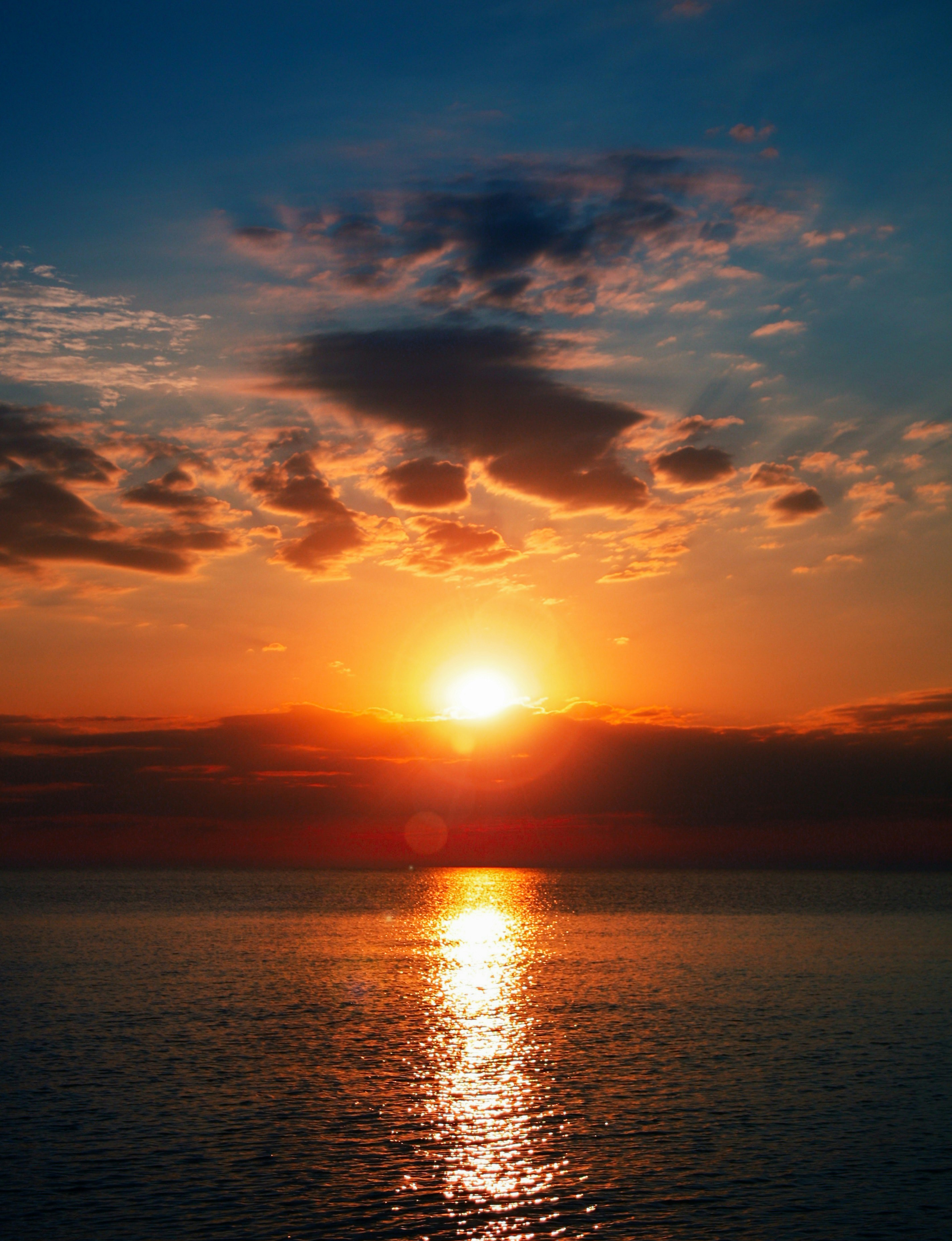 body of water under cloudy sky during sunset