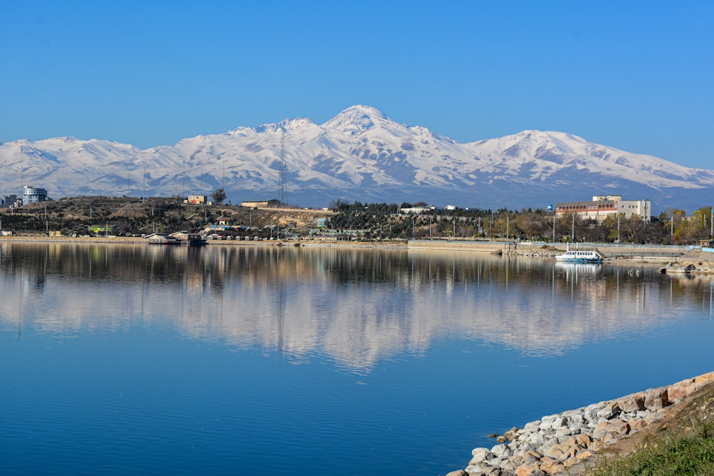 body of water near mountain under blue sky during daytime