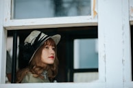 A chic wide-brimmed hat with a delicate ribbon, set against a sunlit window.