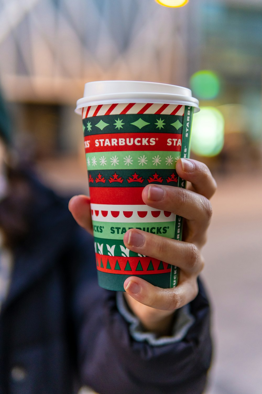 person holding green and white plastic cup