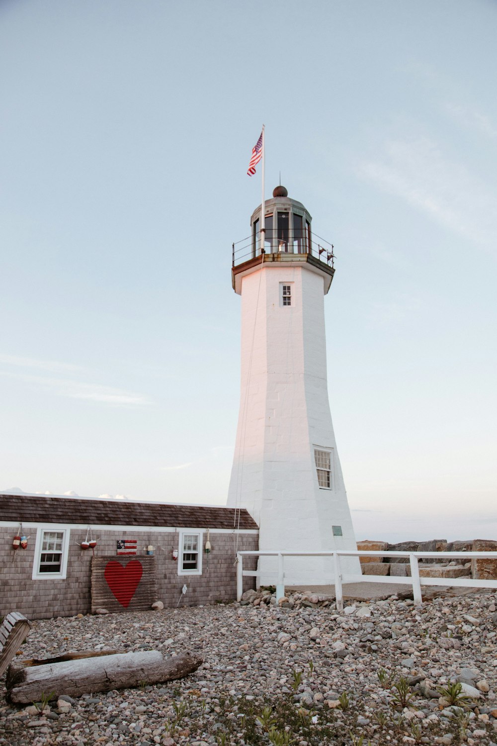 Faro in cemento bianco e rosso sotto il cielo bianco durante il giorno