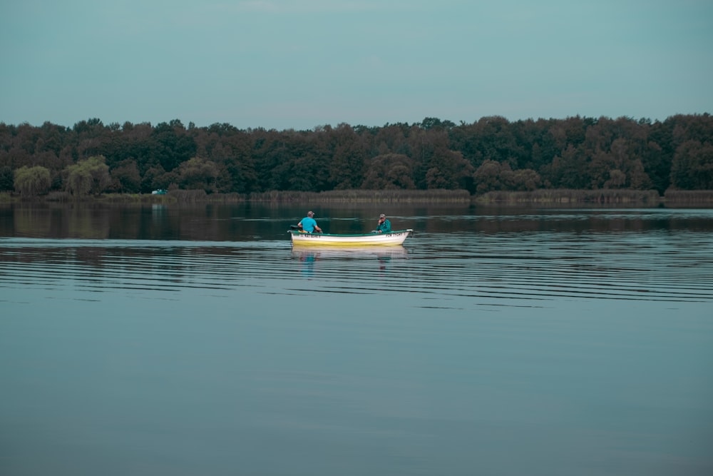 yellow and blue boat on lake during daytime