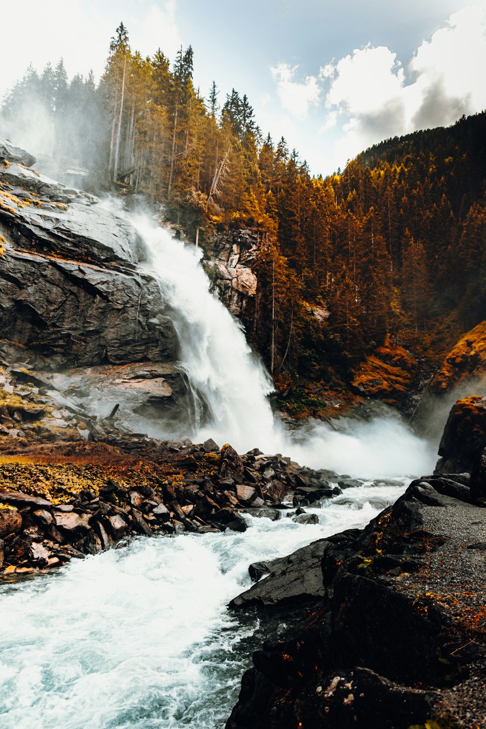 water falls on brown rocky mountain during daytime