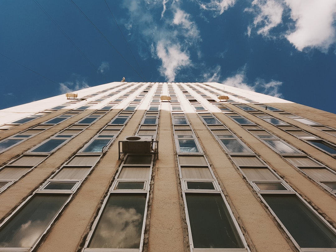 white concrete building under blue sky and white clouds during daytime