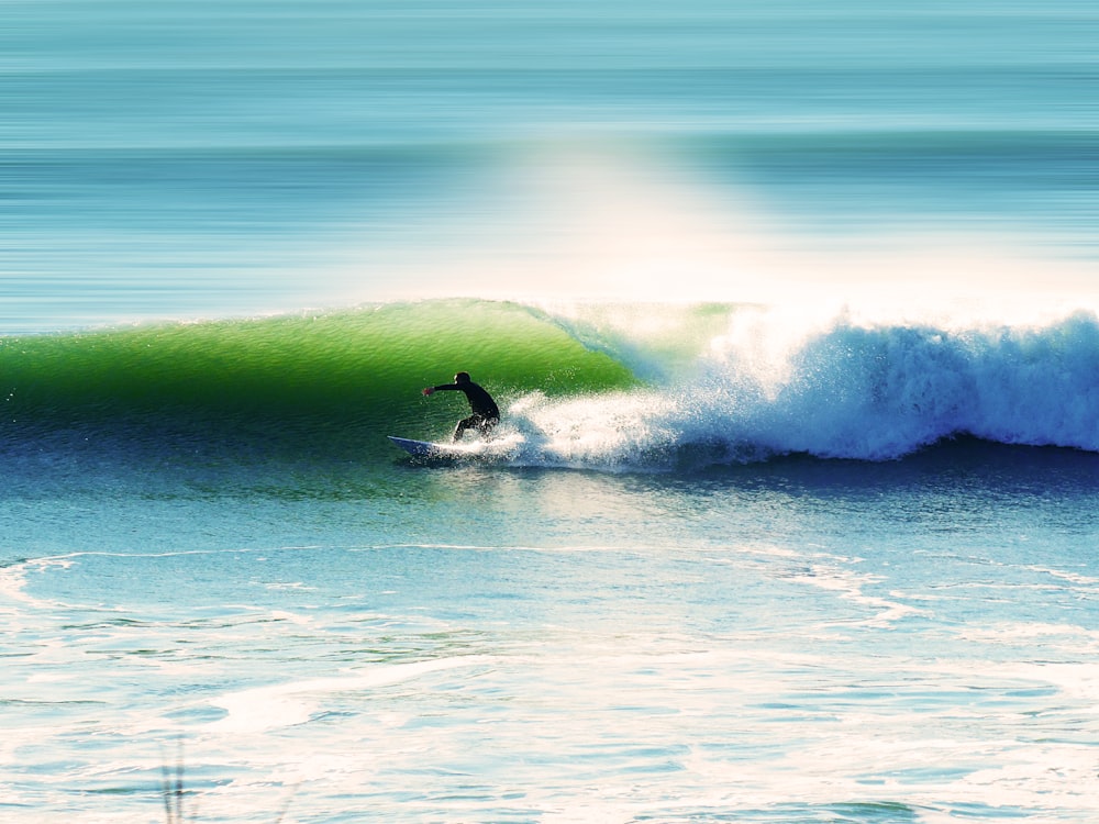 man surfing on sea waves during daytime