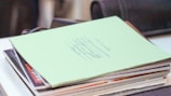 A stack of scientific journals and papers on a desk.