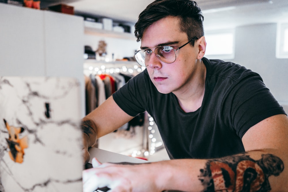 man in black crew neck t-shirt wearing black framed eyeglasses