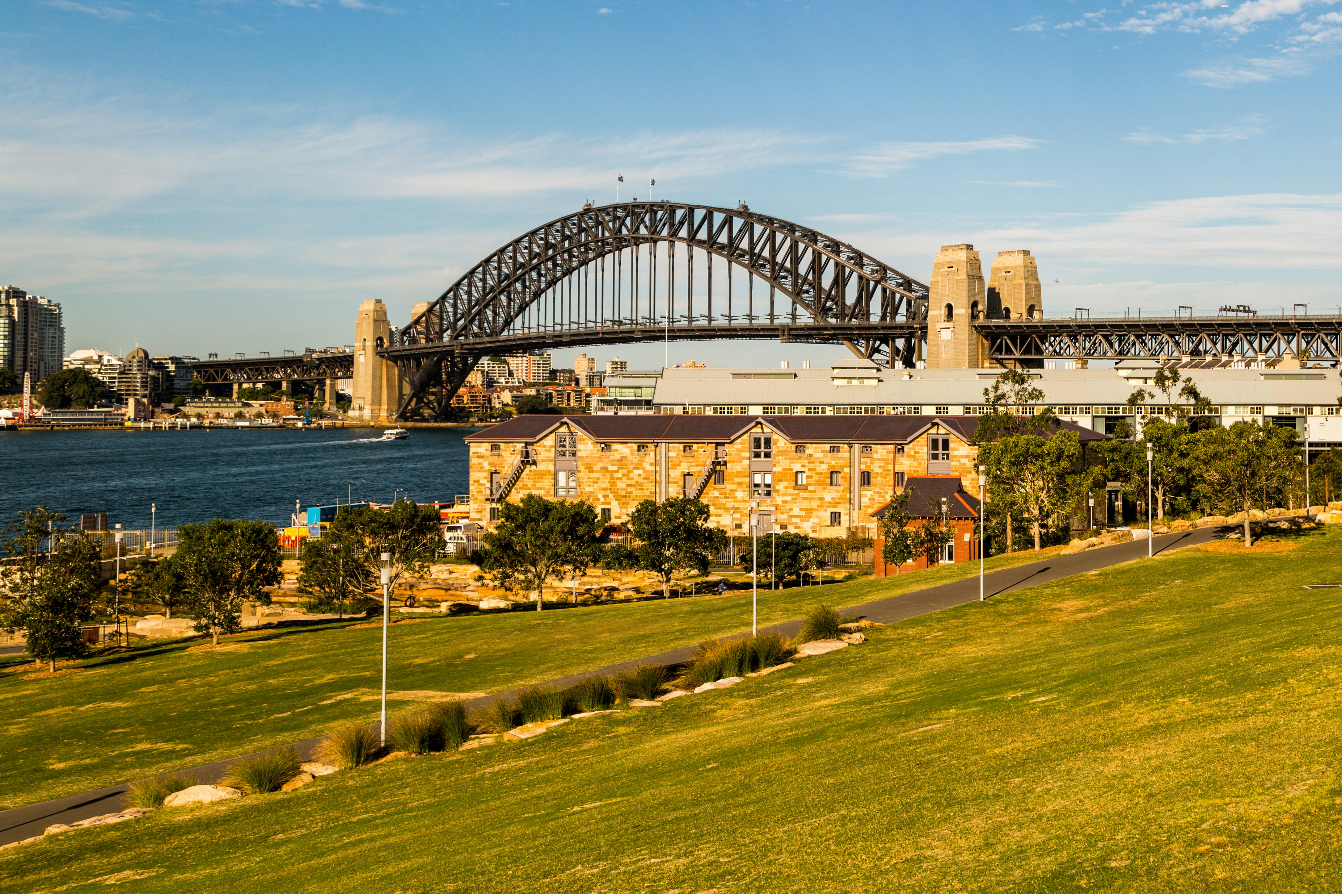 people walking on green grass field near body of water during daytime