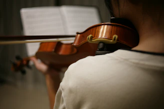 person in white shirt playing violin