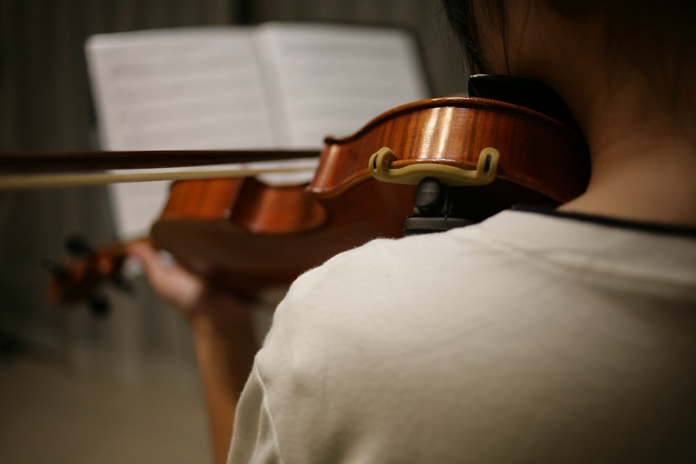 person in white shirt playing violin