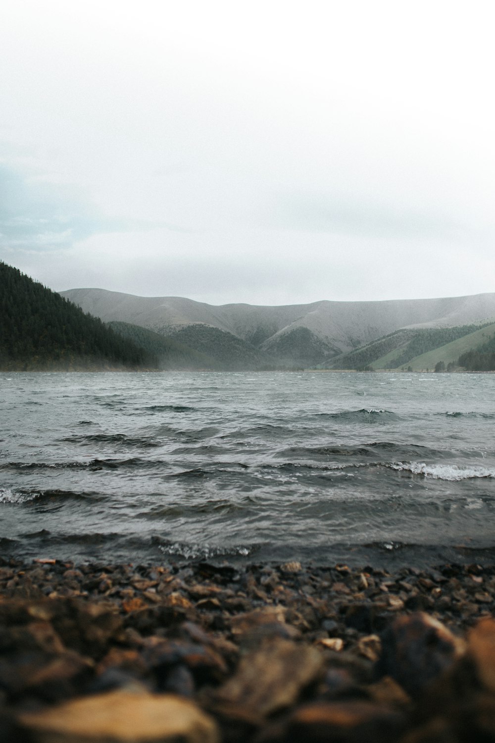 body of water near mountain during daytime