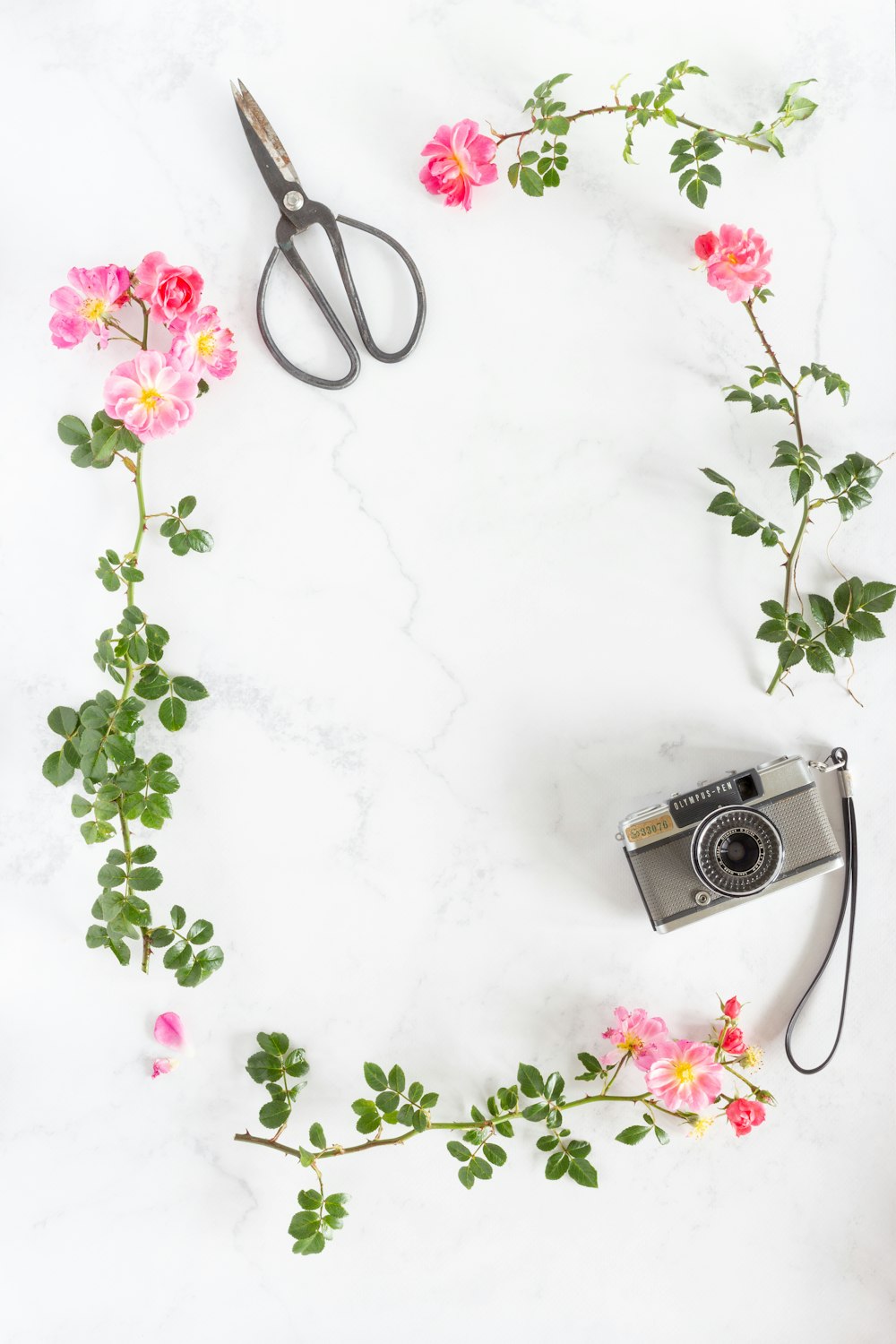 silver and black camera on white floral textile