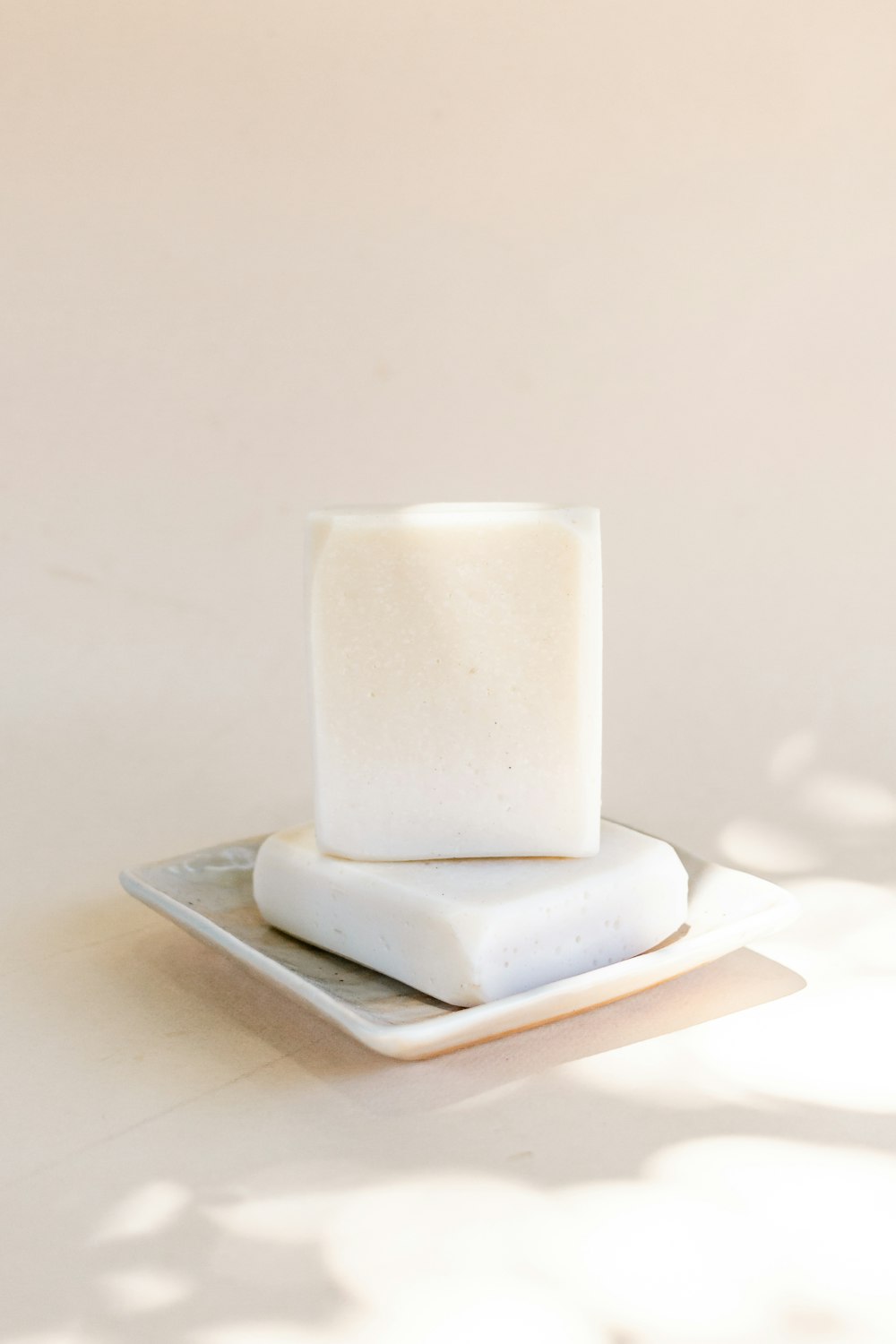 white pillar candle on white ceramic plate