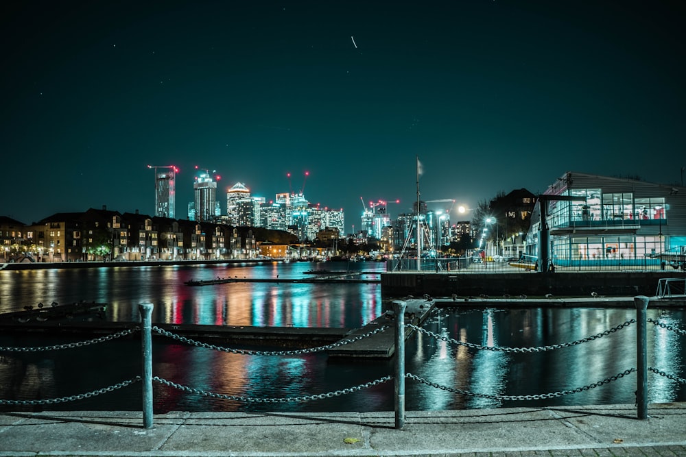 body of water near city buildings during night time