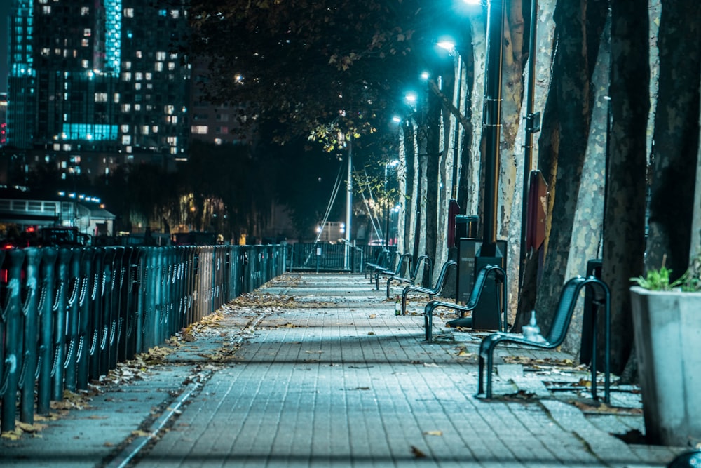 brown wooden bench on sidewalk during night time