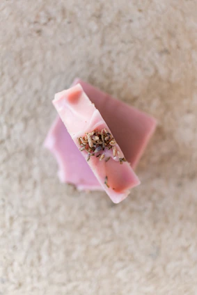 Close-up of a handmade natural soap bar with herbs on a wooden surface