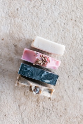 A stack of handmade soaps with natural textures and colors on a linen cloth