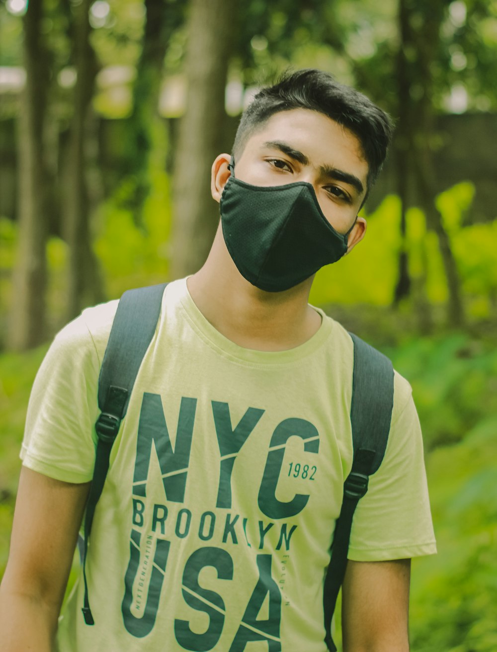 Hombre con camiseta blanca y verde de cuello redondo con gafas negras