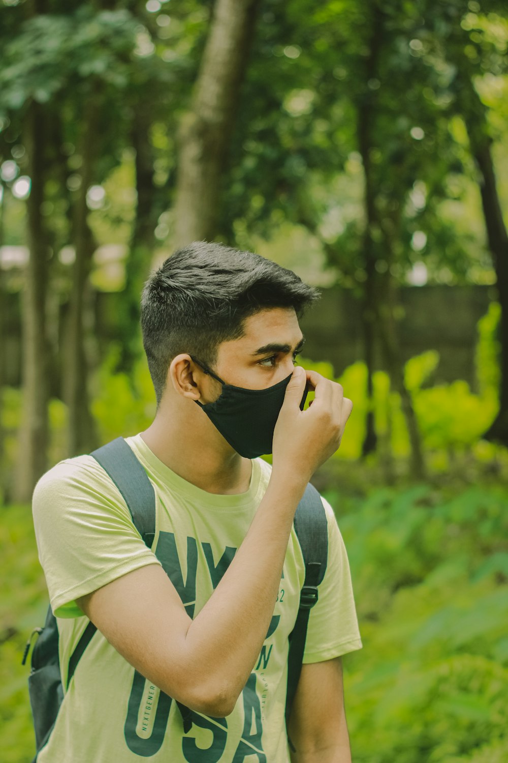 man in white and black tank top covering his face with his hand